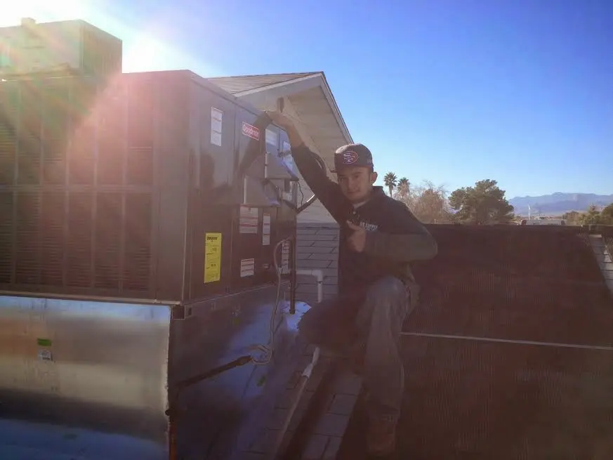 HVAC technician performing AC Tune-Up on a rooftop unit in Kingsland